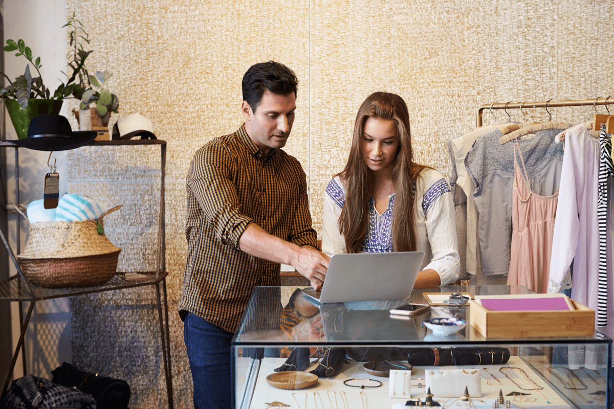 two store associates looking at a laptop